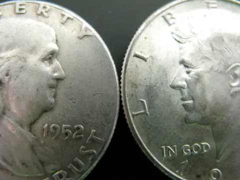 Close-up of a 1952 Franklin half dollar beside a Kennedy half dollar