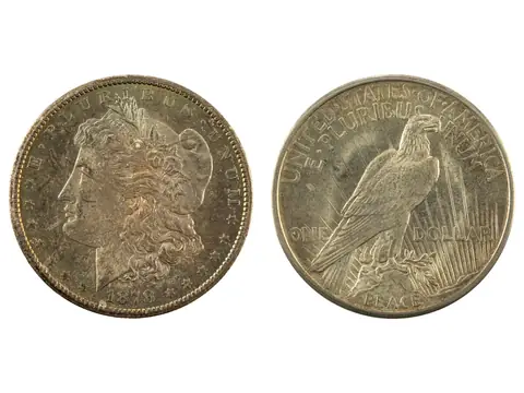 Two US silver dollars side by side: the face of an 1878-CC Morgan dollar and the eagle on the back of a 1921 Peace dollar